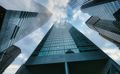 Glass office buildings reflecting the sky.