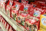 Bags of red Loacker Quadratini Napolitaner chocolate wafer cookies on a supermarket shelf.